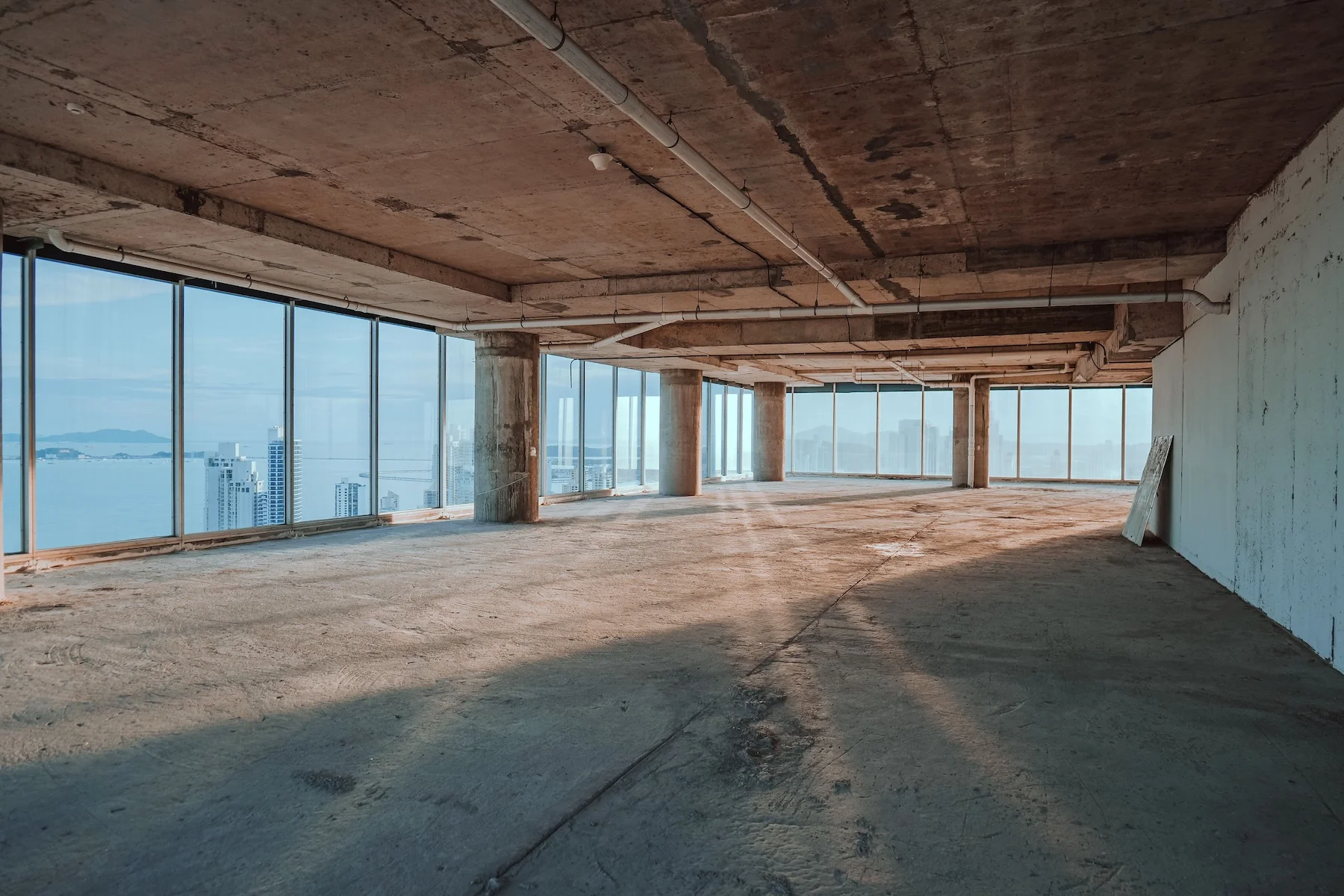 Bürogeschoss im Rohbau mit raumhoher Verglasung und Blick über die Stadt