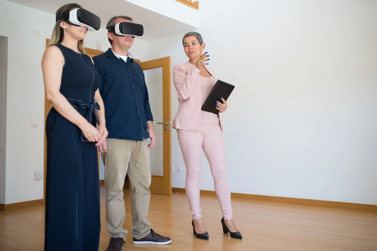 Maklerin im Gespräch mit Interessenten vor der VR-Präsentation